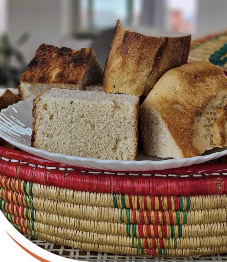 Real photograph of sliced Ethiopian home-baked bread arranged in a colorful woven basket