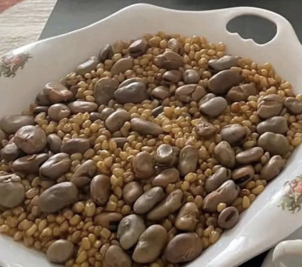 Real photograph of nifro: cooked wheat grains and large beans served together